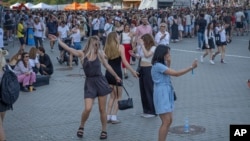 People dance waiting for the start of the Atlas Festival in Kyiv, Ukraine, July 21, 2024.