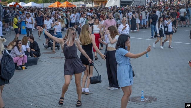 People dance waiting for the start of the Atlas Festival in Kyiv, Ukraine, July 21, 2024.