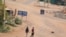 People walk on a deserted street in Khartoum, Apr. 30, 2023, as clashes continue in war-torn Sudan. 