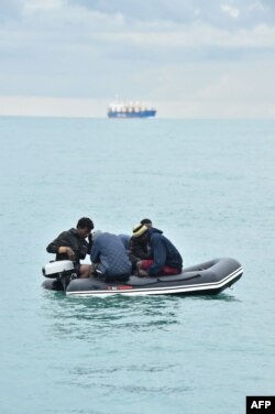 Para migran dengan perahu layar di Selat menuju pantai selatan Inggris, 1 September 2020, setelah menyeberang dari Prancis. (Glyn KIRK /AFP)