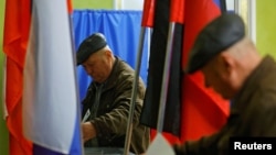A man casts his ballot at a polling station during the Russia's presidential election in the course of Russia-Ukraine conflict in Donetsk, Russian-controlled Ukraine, March 16, 2024.