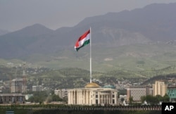 FILE - A national flag of Tajikistan is hoisted to the top of the 165-meter (541.34 feet) flagpole in Dushanbe, Tajikistan, May 24, 2011.
