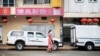 FILE - A woman walks in Cyrildene, also known as Johannesburg's China Town, South Africa, Feb. 07, 2020. Under apartheid, the country's Chinese were among minorities not allowed to vote. That changed on Freedom Day 29 years ago.