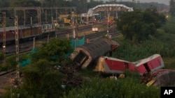 A passenger train passes by the site where two passenger trains derailed Friday in Balasore district, in the eastern Indian state of Orissa, Monday, June 5, 2023. (AP Photo/Rafiq Maqbool)