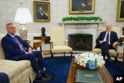 FILE - Speaker of the House Kevin McCarthy of California, left, listens as President Joe Biden speaks about the debt limit in the Oval Office, in Washington, May 9, 2023.