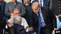 Pakistan's Prime Minister Shehbaz Sharif, right, meets with senior politician Aftab Shaban Mirani before a group photograph with parliamentarians of the National Assembly, outside the parliament building in Islamabad, Aug. 9, 2023. 