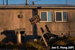 A homemade basketball hoop stands tilted outside a home in the Alaska Native village of Shishmaref, Saturday, Oct. 1, 2022.