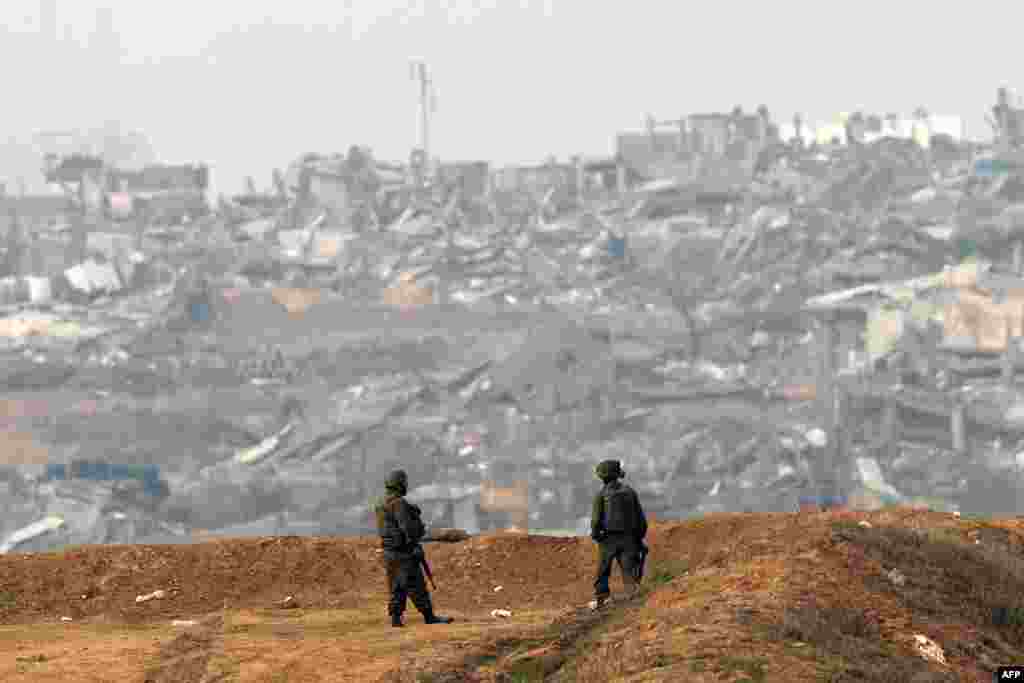 Israeli soldiers walk along the Israel-Gaza border, amid ongoing battles between Israel and the Palestinian militant group Hamas.