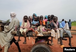FILE - Sudanese children, who fled the conflict in Murnei in Sudan's Darfur region, ride a cart while crossing the border between Sudan and Chad in Adre, Chad, Aug. 4, 2023.