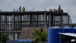 FILE - Construction workers are seen putting up a new development outside Phnom Penh, Cambodia, Aug. 29, 2022. Thousands of Cambodians have become victims of real estate financing schemes and are now struggling to pay back loans.