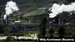 FILE - Seorang warga mengendarai sepeda motor di jalan dekat unit pembangkit listrik tenaga panas bumi (PLTP) milik PT. Geo Dipa Energi (Persero) di kawasan pegunungan Dieng di Banjarnegara, Jawa Tengah, Indonesia, 15 November 2020. (Willy Kurniawan/REUTERS)