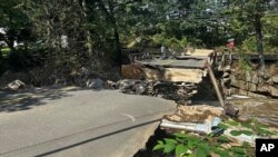 A bridge washed out in Oxford, Conn., after torrential rains turned streets into raging rivers in parts of Connecticut and New York's Long Island, trapping people in cars and sweeping two women to their deaths, authorities said, Aug. 19, 2024.