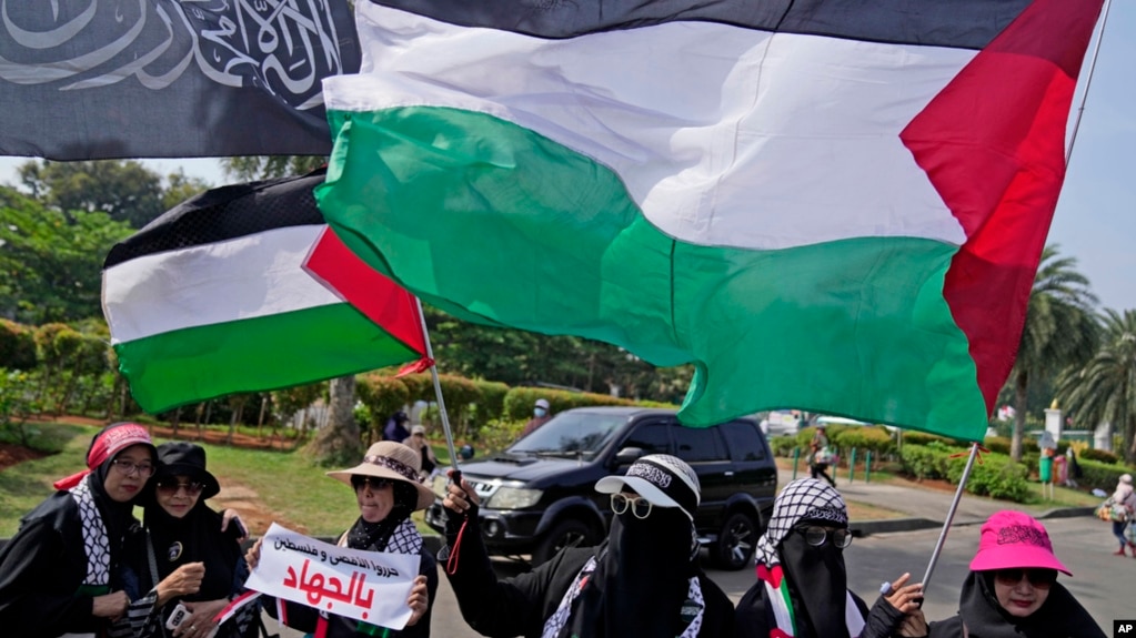 Indonesian Muslim women wave Palestinian flags during a rally in support of Palestinians, in Jakarta, Indonesia, Oct. 13, 2023. 