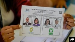 An electoral official shows the ballot with the candidates for the runoff presidential election in Guatemala City, Aug. 20, 2023. 