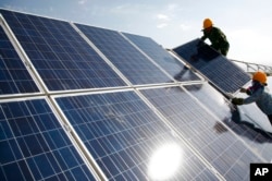Workers install solar panels at a power station in Hami, China, Aug. 22, 2011. The Biden administration plans new import levies on solar cells, among other Chinese products.