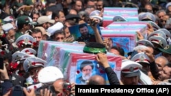 Flag-draped coffins of the President Ebrahim Raisi and his companions who were killed in a helicopter crash are carried during their funeral ceremony. Mashhad, Iran, May 23, 2024. (Iranian Presidency Office via AP)