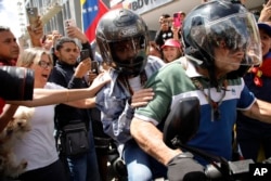 Opposition leader Maria Corina Machado is driven away on a motorbike at the end of a rally in Caracas, Venezuela, Aug. 3, 2024.