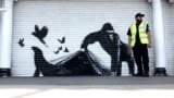 An artwork by street artist Banksy, the ninth to be released in nine days, depicts a gorilla releasing animals, on the front of a shutter outside London zoo.