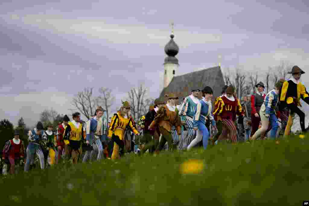 Local residents of the region wearing traditional costumes make their way to get blessings for men and animals, at the St. George church in Traunstein, Germany. (AP Photo/Matthias Schrader)