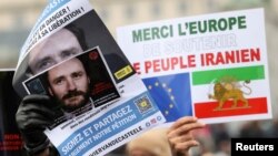 FILE - People hold pictures of Belgian aid worker Olivier Vandecasteele during a protest against his detention in Iran, in Brussels, Jan. 22, 2023. Iran released him May 26, 2023, in a deal for an Iranian diplomat.