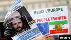 People hold pictures of Belgian aid worker Olivier Vandecasteele during a protest against his detention in Iran, in Brussels, Jan. 22, 2023.