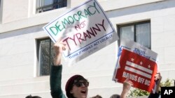 Manifestantes sostienen carteles durante una protesta frente al edificio de oficinas del Senado Dirksen, el miércoles 8 de marzo de 2023, en Capitol Hill en Washington. (Foto AP/Mariam Zuhaib)