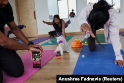 Peserta melakukan yoga saat anak kucing bermain di sekitar mereka dalam sesi yoga di sebuah studio di New Delhi, India, 6 Agustus 2023. (Foto: REUTERS/Anushree Fadnavis)