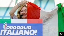 FILE — Giorgia Meloni holds an Italian flag as she addresses a rally in Rome, Oct. 19, 2019.