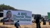 People walk past a ruling Zanu PF poster thanking Zimbabweans for voting for President Emmerson Mnangagwa, in Harare, Sept. 4, 2023. (Columbus Mavhunga/VOA)