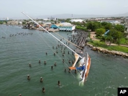A boat damaged by Hurricane Beryl lays on its side at a dock in Kingston, Jamaica, July 4, 2024.