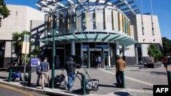 Members of the media stand outside the Brisbane Watch House in Brisbane on July 12, 2024, where a 40-year-old woman and her 62-year-old husband appeared before a magistrate after being charged with "preparing for an espionage offense".