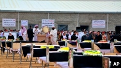 FILE - Mourners prepare to bury the remains of Yazidi victims in a cemetery in Sinjar, Iraq, on Feb. 6, 2021. Some 104 Yazidis killed by the Islamic State group in 2014 were given a proper burial in the country's north. The bodies were exhumed from mass graves in 2020.