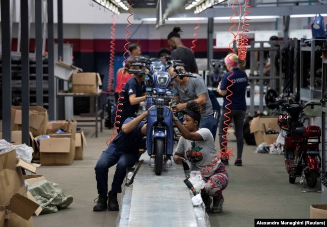 Workers assemble scooters at the Caribbean Electric Vehicles (VEDCA) factory in Havana, Cuba, July 15, 2024. (REUTERS/Alexandre Meneghini)