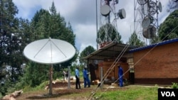 Technicians relax after the final adjustments were made to satellite equipment for VOA's new radio station serving Kirongi, Rwanda.
