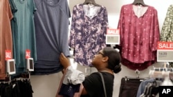 FILE - In this Aug. 28, 2018, photo, a shopper looks for clothing at a Kohl's store in Concord, North Carolina. "Fast-fashion" — inexpensive and trendy clothes — is causing environmental problems worldwide. 