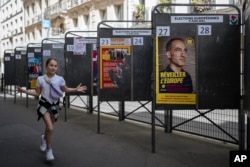 A child walks by campaign posters during the European Parliament elections, June 9, 2024, in Paris.
