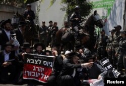 Ultra-Orthodox Jewish men gather after the Supreme Court ruled the defense ministry could no longer grant blanket exemptions to Jewish seminary students from military conscription, at Tel HaShomer recruitment base, in Ramat Gan, Israel, Aug. 5, 2024.