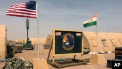 FILE - U.S. and Nigerien flags are raised at Air Base 201 in Agadez, Niger, April 16, 2018. Air Base 201 is one of two bases U.S. troops have used while stationed in Niger.