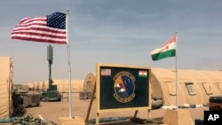 FILE - U.S. and Niger flags are raised at the base camp for air forces and other personnel supporting the construction of Niger Air Base 201 in Agadez, Niger, April 16, 2018. (AP/Carley Petesch)