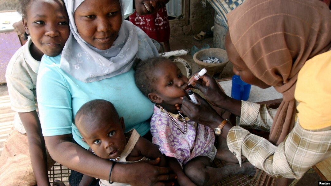 Seorang pekerja sosial memberikan obat tetes polio kepada seorang anak di di Khartoum. Kampanye yang disponsori pemerintah menargetkan anak-anak di bawah usia 5 tahun. (Foto: REUTERS/Mohamed Nureldin Abdalla)