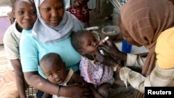 Seorang pekerja sosial memberikan obat tetes polio kepada seorang anak di di Khartoum. Kampanye yang disponsori pemerintah menargetkan anak-anak di bawah usia 5 tahun. (Foto: REUTERS/Mohamed Nureldin Abdalla)