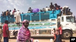 FILE - People board a truck as they leave Khartoum, Sudan, June 19, 2023.