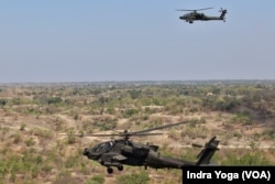 Helikopter Apache TNI Angkatan Darat (atas) dan Angkatan Darat Amerika Serikat (bawah) bekerja sama menembak sasaran target dalam latihan Combined Arms Live-Fire Exercise (CALFEX) Super Garuda Shield 2023 di Baluran, Jawa Timur, Senin, 11 September 2023. (Foto: Indra Yoga/VOA)