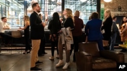 People mingle at a Philadelphia Distilling Daters Mixer Hosted by Date Him Philly, in Philadelphia, Tuesday, Nov. 14, 2023. (AP Photo/Matt Rourke)