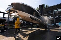 A boat's hull is cleaned after it was pulled out of the water in advance of Hurricane Lee at York Harbor Marine, Sept. 14, 2023, in York, Maine.