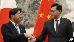 জাপানের পররাষ্ট্রমন্ত্রী ইয়োশিমাসা হায়াশি (বামে), বেইজিং-এর দিয়াওইউতাই স্টেট গেস্ট হাউজে চীনের পররাষ্ট্রমন্ত্রী কিন গ্যাং-এর সাথে করমর্দন করছেন; (এপির মাধ্যমে পাওয়া কিয়োডো নিউজ-এর ছবি), ২ এপ্রিল ২০২৩।