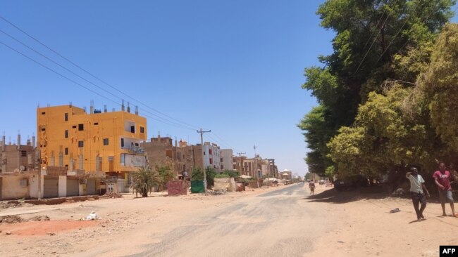 People walk along a deserted street in southern Khartoum, as violence between two rival Sudanese generals continues, on May 17, 2023.