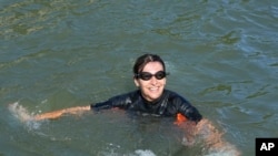 FILE - Paris Mayor Anne Hidalgo swims in the Seine river, July 17, 2024 in Paris. After months of anticipation, Anne Hidalgo swam in the Seine Rive, fulfilling a promise she made in January nine days before the opening ceremony of the 2024 Olympics.