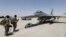 FILE - U.S. Army soldiers look at an F-16 fighter jet during an official ceremony to receive four such aircraft from the United States, at a military base in Balad, Iraq, July 20, 2015.