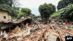Residents look at the destruction caused by a landslide in the district of Mbankolo, northwest of Yaounde, Cameroon, Oct. 9, 2023. Heavy rains caused a section of a hillside covered in precariously built houses to collapse.
